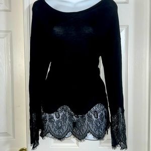 Black long-sleeved shirt w/ lace @ end of sleeves & bottom of shirt. New w/ tags